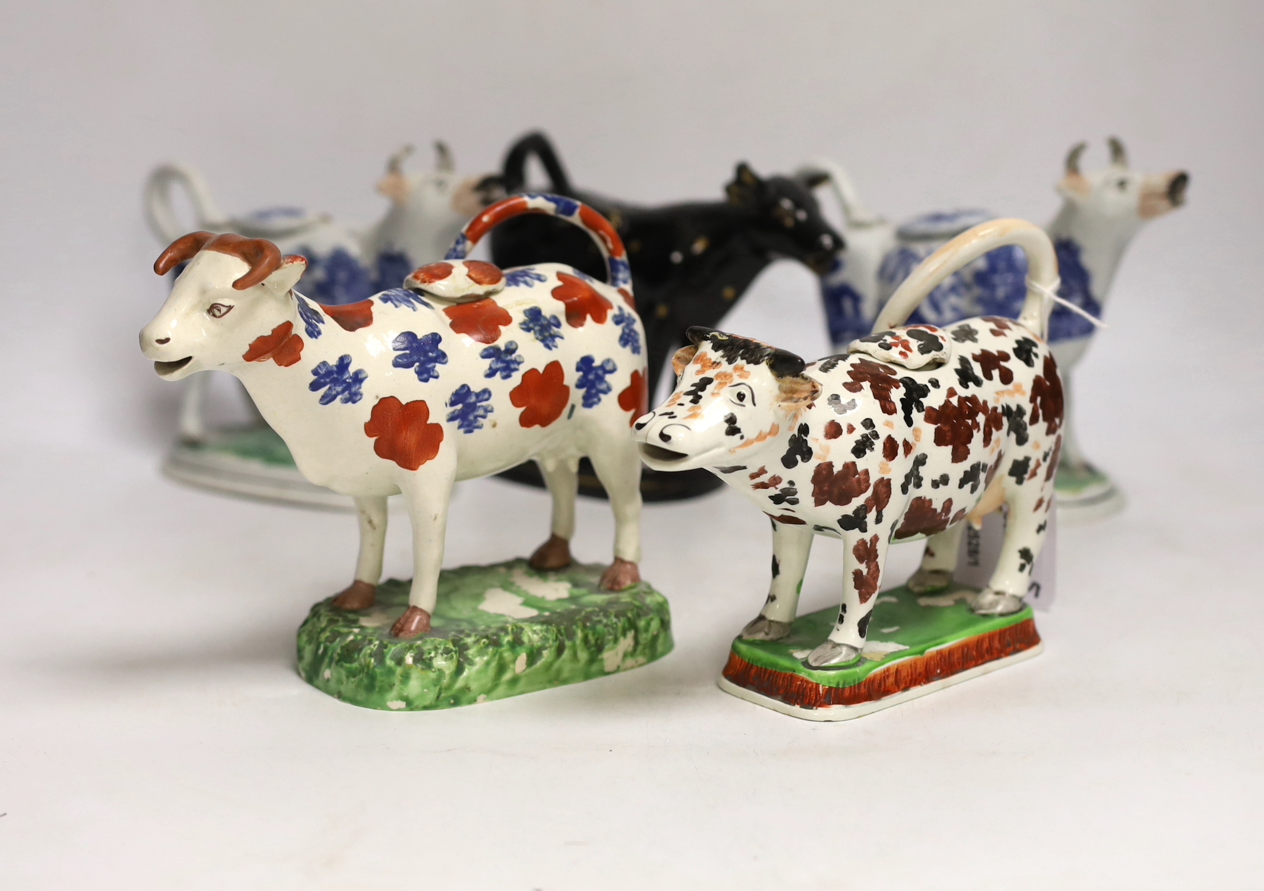 Five 19th century Staffordshire cow creamers, largest 18cm wide